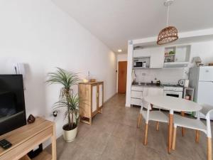 a kitchen and living room with a table and a tv at La Nona Nidia in Paraná