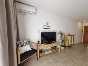 a living room with a tv and a chair at La Nona Nidia in Paraná