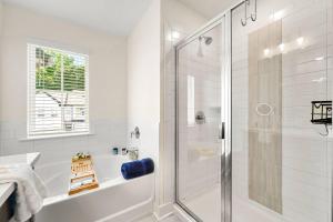 een witte badkamer met een douche en een bad bij Modern Townhome in Auburn in Auburn +27 foto's
