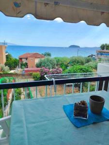 une table sur un balcon avec vue sur l'océan dans l'établissement Ocean Blue, à PalaiónTsiflíkion