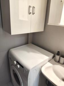 - un lave-linge et un sèche-linge dans une salle de bains à côté d'un lavabo dans l'établissement Ocean Blue, à PalaiónTsiflíkion