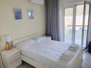 un lit blanc avec deux serviettes dessus dans une chambre dans l'établissement Ocean Blue, à PalaiónTsiflíkion