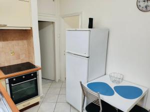 une cuisine avec un réfrigérateur blanc et une table dans l'établissement Ocean Blue, à PalaiónTsiflíkion