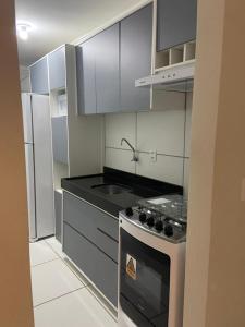 a kitchen with a stove and a refrigerator at Apartamento em Garanhuns in Garanhuns