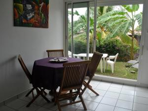 a dining room with a purple table and chairs at CoCoKreyol - " ARUBA" in Les Trois-Îlets
