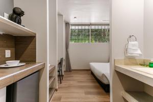 a bathroom with a sink and a bed in a room at Wenceslao By Homirent in Querétaro