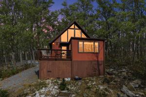 a tiny house in the woods with a balcony at Cozy Chalet & Luxe Domes Retreat w Stunning Views in Augusta
