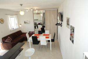 a living room with a couch and a table with chairs at Olive Apartments in Ugljan
