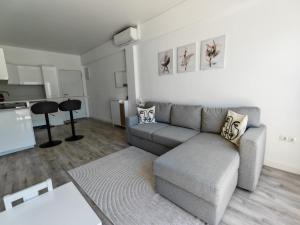 a living room with a couch and a kitchen at Apartamentos playa Romanilla in Roquetas de Mar +9 photos
