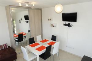 a dining room with a white table and chairs at Olive Apartments in Ugljan