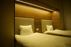 two twin beds in a room with a mirror at Jon Apartments in Peje