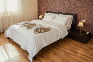 ein Schlafzimmer mit einem großen Bett mit weißen Laken und Decken in der Unterkunft Roda Luxury Beach House in Roda