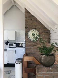 a kitchen with a clock on a brick wall at Globetrotter in Bergen
