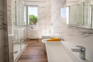 a white bathroom with a sink and a toilet at Villa Reitani San Lorenzo - SiciliaVacanza in San Lorenzo +44 photos