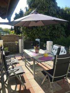 a table and chairs with an umbrella on a patio at Zentral im Grünen in Dortmund