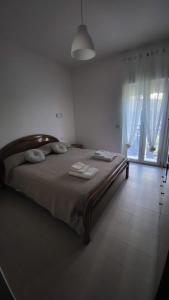 a bedroom with a large bed and a large window at Domus in Horto in Perdifumo