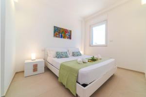 a white bedroom with a bed and a window at Onde Chiare a 100metri da spiaggia solo sabbia in Torre Santa Sabina
