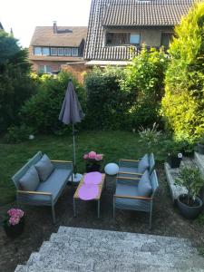 a patio with two couches and an umbrella at Zentral im Grünen in Dortmund