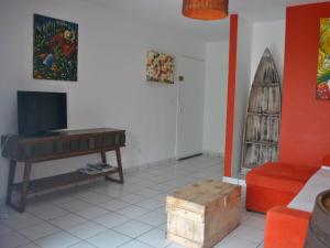 - un salon avec une télévision, une table et un canapé dans l'établissement CoCoKreyol - " ARUBA", à Les Trois-Îlets