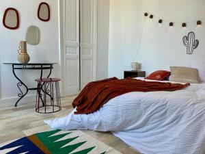 a bedroom with a bed and a table in it at L'Oasis - Halles Châtellerault in Châtellerault