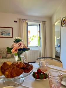 a table with a plate of food and flowers on it at Casa Angela in Toscolano Maderno +73 photos