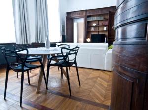 een woonkamer met een witte bank en een tafel en stoelen bij Le Boudoir 137 in Bordeaux