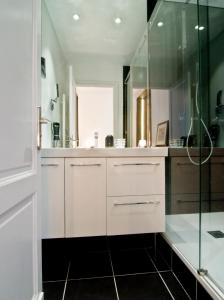 een badkamer met witte kasten en een glazen douche bij Le Boudoir 137 in Bordeaux