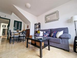 a living room with a blue couch and a table at Casa Triana in Costa Teguise