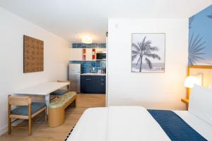 a room with a bed and a desk and a table at The Sunshine Hotel and Suites in George Town