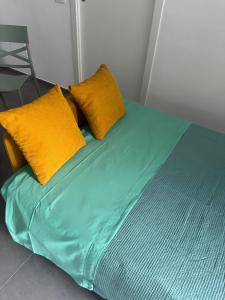 - un lit avec des draps et des oreillers jaunes et verts dans l'établissement La casetta di Lu' Loft con 1 camera da letto, à Fasano