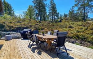 a wooden table and chairs on a wooden deck at 4 Bedroom Nice Home In Vinje in Trovatn +24 photos