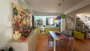 eine Küche und ein Wohnzimmer mit einem Tisch und einer Küche in der Unterkunft Casa Vicoli e Mare in Maratea + 1 Foto