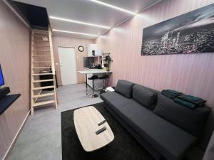 ein Wohnzimmer mit Sofa und Tisch in der Unterkunft Tiny House Disney in Coutevroult