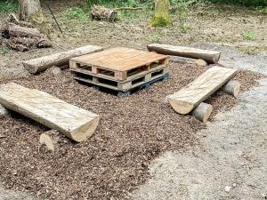 ein Holztisch und Baumstämme auf dem Boden in der Unterkunft The Barn At Fishponds in Brook + 3 Fotos