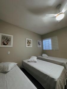 een slaapkamer met twee bedden en een plafondventilator bij cantinho da padroeira in Aparecida