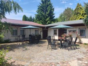 a patio with chairs and tables and umbrellas at Studio in Ribnitz-Damgarten 36833 in Ribnitz-Damgarten