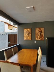 een eetkamer met een houten tafel en stoelen bij cantinho da padroeira in Aparecida