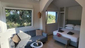 a bedroom with a bed and a couch and a table at Casa O' - House with private Pool in Limenas