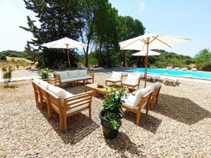 a group of chairs and umbrellas next to a pool at Casa Rural El Contarín - An Andalusian Escape, Archidona, Malaga in Archidona