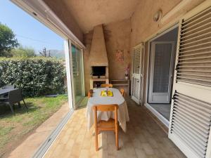 a patio with a table and chairs on a porch at La Dolce Villa avec Piscine in Zonza