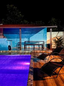 ein Tisch und Stühle auf einer Terrasse bei Nacht in der Unterkunft Chalé com piscina in Alto Paraíso de Goiás