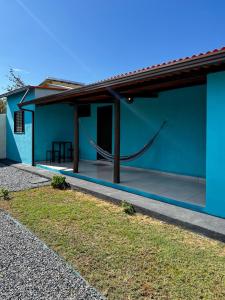 ein blaues Haus mit einer Hängematte davor in der Unterkunft Chalé com piscina in Alto Paraíso de Goiás