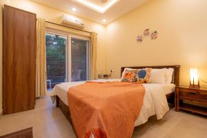 a bedroom with a bed and a window at Siolim by nidra stays in Siolim