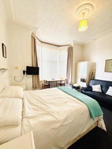 a bedroom with a large white bed and a couch at Springfield Holiday Apartments HALodge Hotel in Skegness