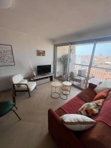 a living room with a couch and a large window at Beautiful apartment with sea view in Le Grau-du-Roi +12 photos