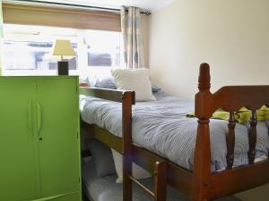 a bedroom with a bunk bed with a green cabinet at Sandy Den in Scratby
