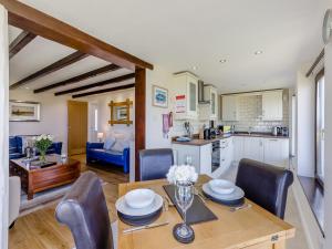 a kitchen and dining room with a table and chairs at Bay View Cottage in Llanon