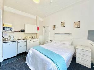 a white bedroom with a bed and a kitchen at Springfield Holiday Apartments HALodge Hotel in Skegness