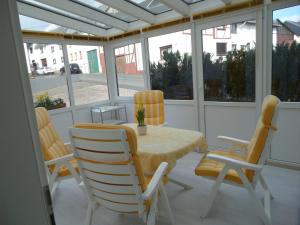 a screened porch with a table and chairs at Historisches Fachwerkhaus in Reifferscheid