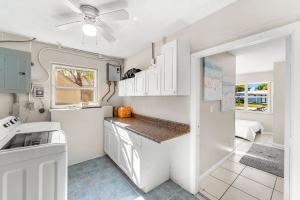 a kitchen with white cabinets and a ceiling fan at 721 Java Rd in Cocoa Beach